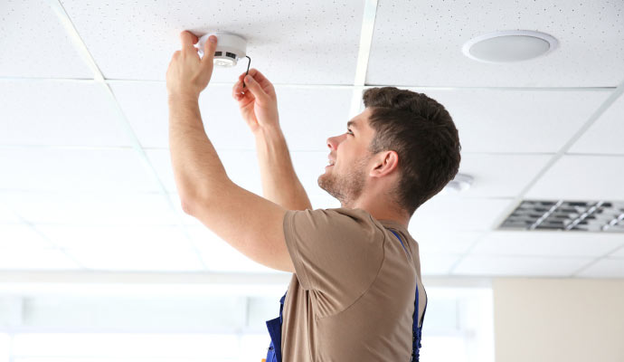 an electrician installing smoke detector